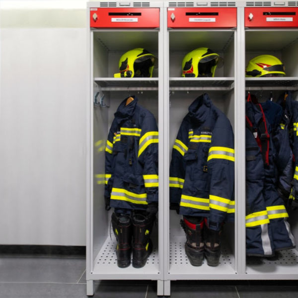 Blick auf die Feuerwehreinsatzbekleidung einschließlich der Schuhe und Helme, aufbewahrt im Spind für Feuerwehrleute ALFA3 